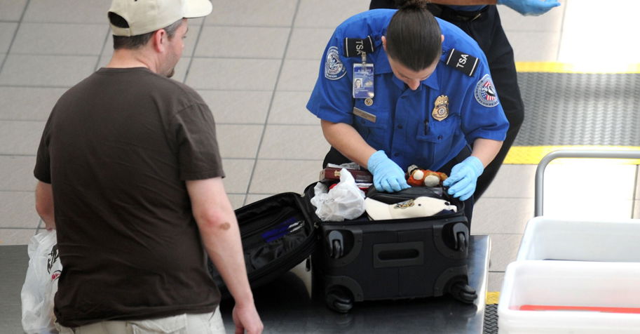 TSA-agent inspecteert de koffer van een reiziger